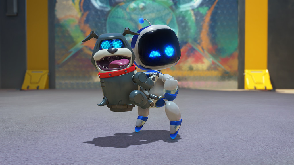 This image is a close up of a winking Astro Bot, who proudly displays a robotic hound who’s positioned on his back like a backpack.