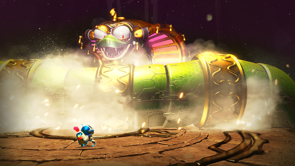 In this image, with a metal rooster clad to his back, Astro Bot observes a mammoth metallic cobra, the tail of which slithers across the platform in front, kicking up dust. Behind that green and gold-bangled body rises the snake’s head.